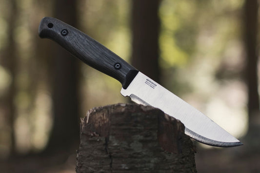 Bushcraft knife on a wooden log in the forest